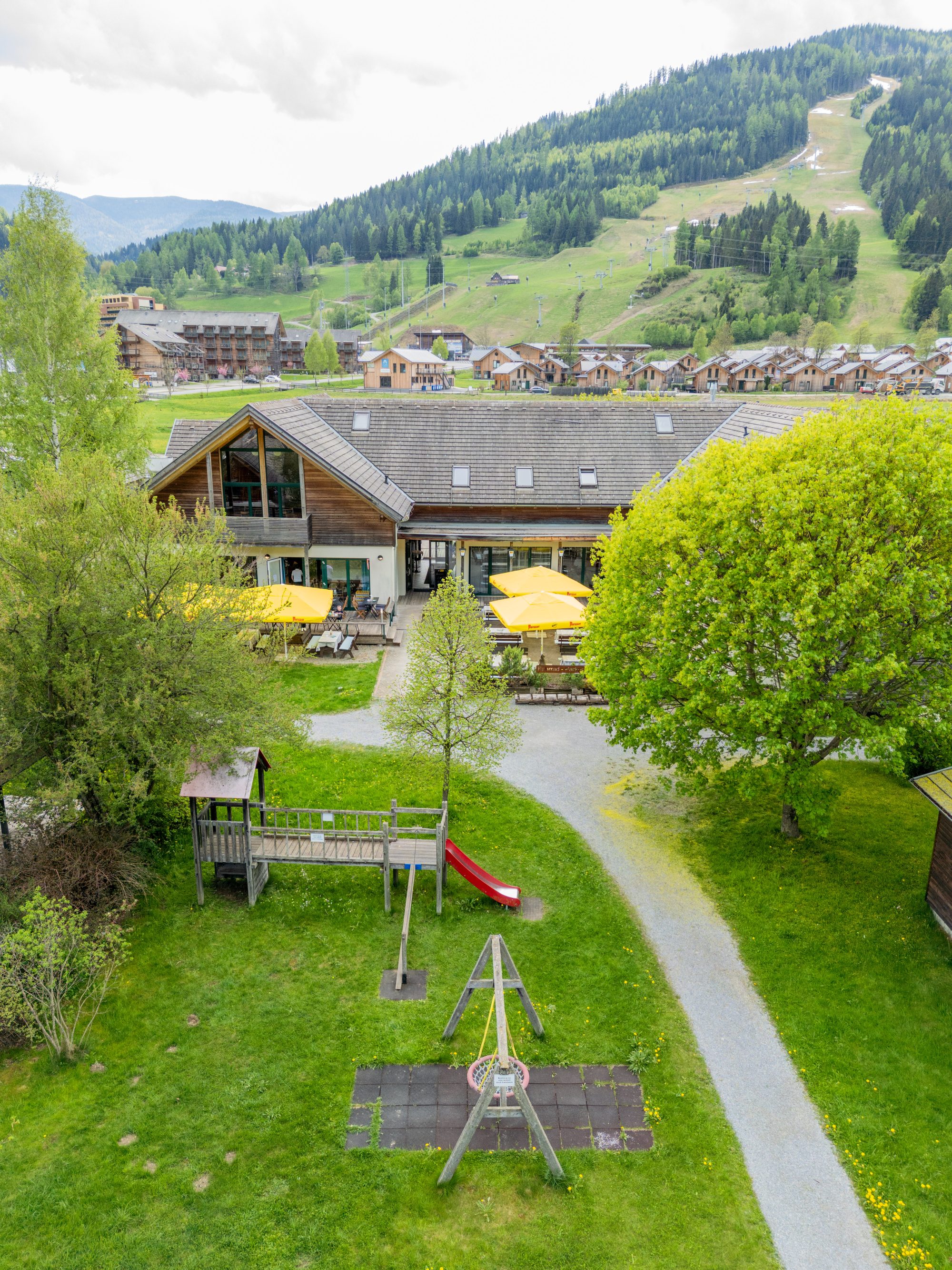 Der Georgenwirt am Kreischberg von oben, mit Piste und Ferienpark